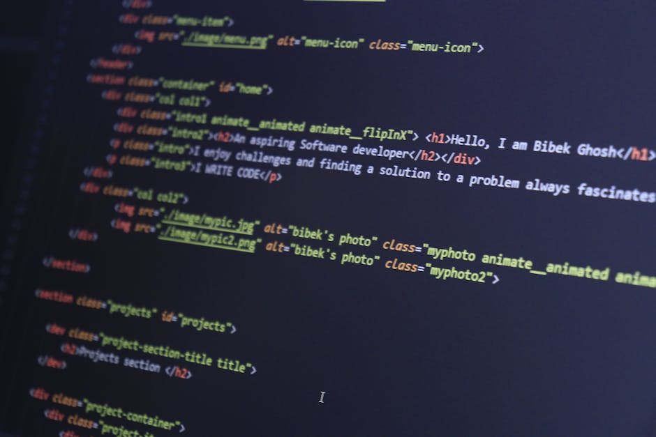 A photograph of a computer screen displaying lines of HTML code in various colors including yellow, blue, red, and white. The code contains tags and attributes for web development, with visible sectio